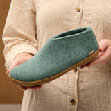 Person holding a north sea slipper with a beige background