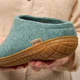 North sea slipper with rubber sole held by a person wearing a beige sweater.