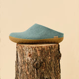 North sea slipper with rubber sole on a wooden stump against a beige background