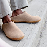 Sand slippers worn by a person on a concrete surface