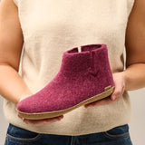 Person holding a wool boot with a neutral background