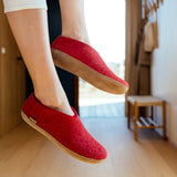 Red slippers worn indoors with a blurred background