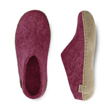 Pair of cranberry slippers with leather soles on a white background