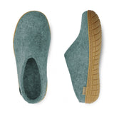 Pair of teal slippers with rubber soles on a white background