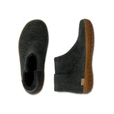 Pair of green ankle boots with  honey rubber soles on a white background