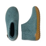 Pair of teal slippers with honey rubber  soles on a white background
