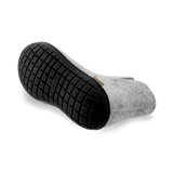 Bottom view of a Grey wool boot with a black rubber sole.