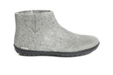 Gray ankle boot with black sole on a white background