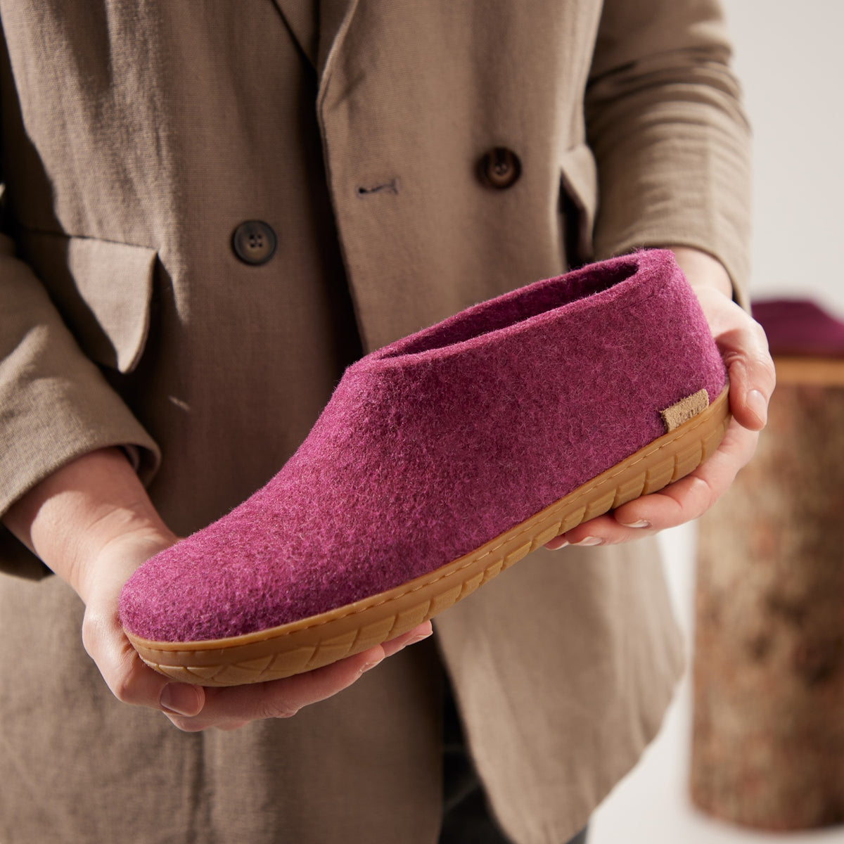 Person holding a cranberry slipper with a honey rubber sole