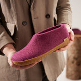 Person holding a cranberry slipper with a honey rubber sole