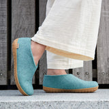 North Sea shoes with brown soles worn by a person standing on concrete. 