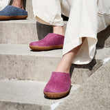 Person wearing cranberry slippers with rubber soles on concrete steps