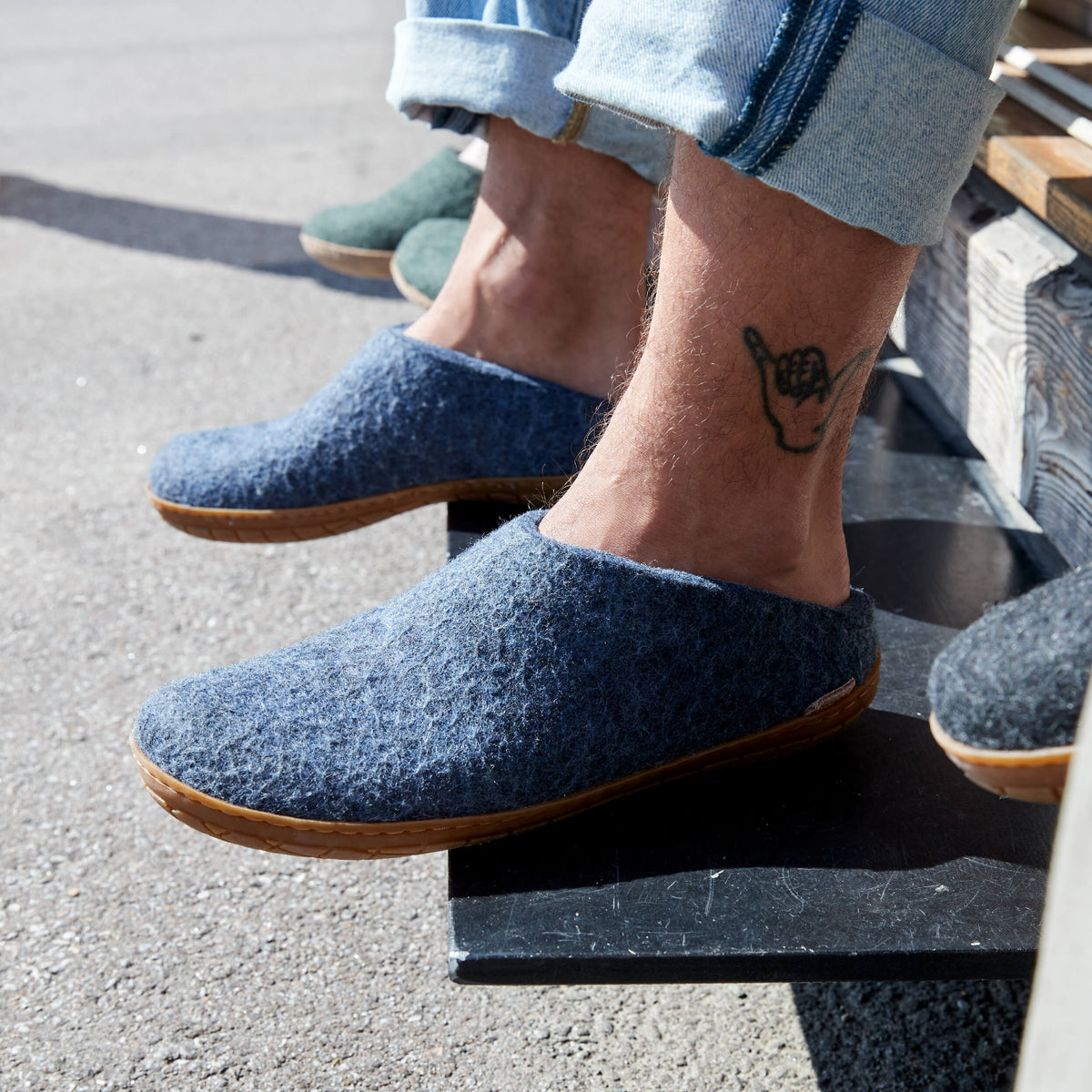 Person wearing denim slippers with rubber soles on a step.