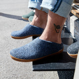 Person wearing denim slippers with rubber soles on a step.