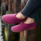 Cranberry felt shoes being worn with a blurred background