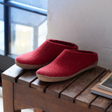 Red slippers on a wooden surface with a blurred background