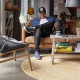 Man sitting on a couch with a dog in a modern living room