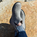Gray slip-on shoes worn on a rocky surface